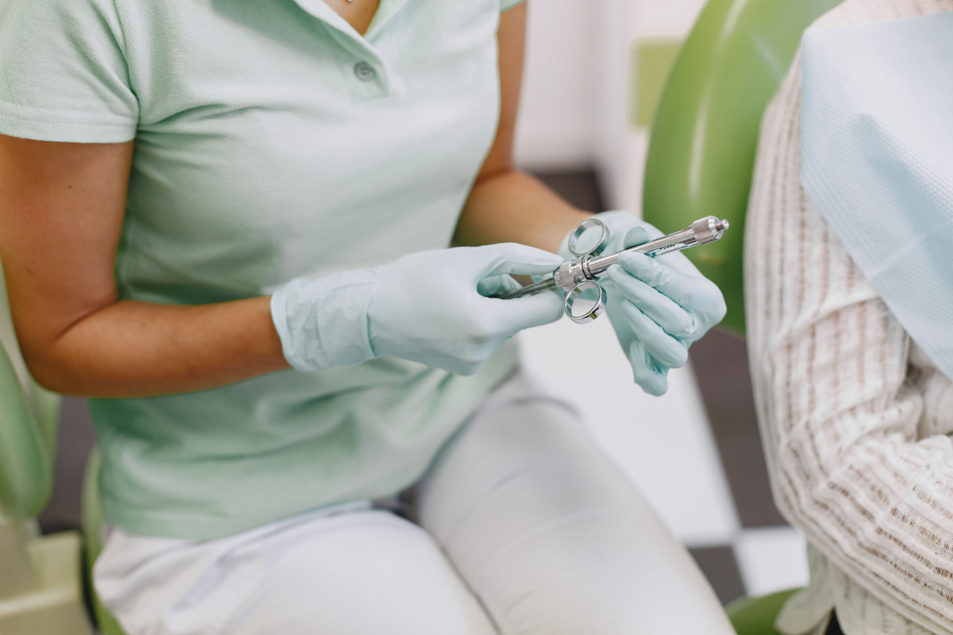 Mani del dentista con una siringa prima di un intervento di chirurgia orale